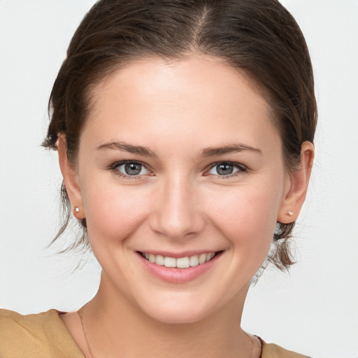 Joyful white young-adult female with medium  brown hair and grey eyes