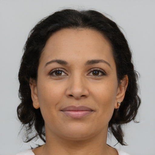 Joyful latino young-adult female with medium  brown hair and brown eyes