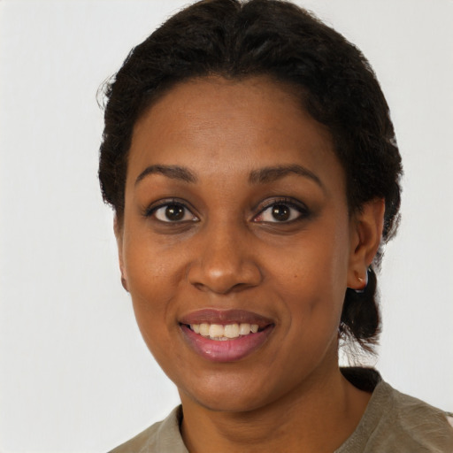 Joyful black young-adult female with short  black hair and brown eyes
