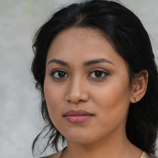 Joyful latino young-adult female with medium  brown hair and brown eyes