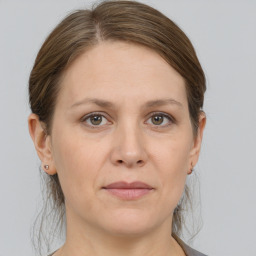 Joyful white adult female with medium  brown hair and grey eyes