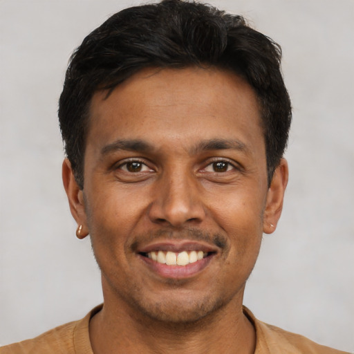 Joyful latino young-adult male with short  black hair and brown eyes