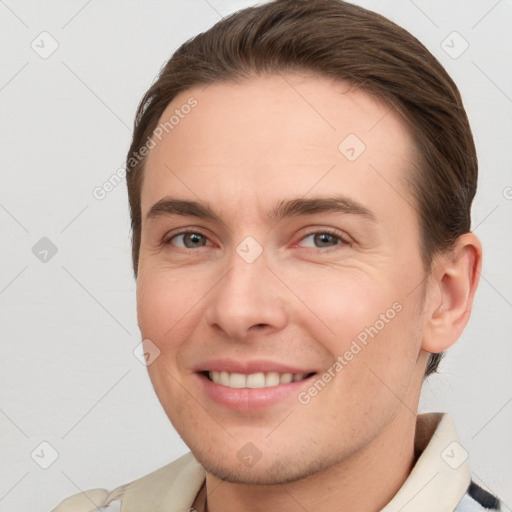 Joyful white young-adult male with short  brown hair and grey eyes