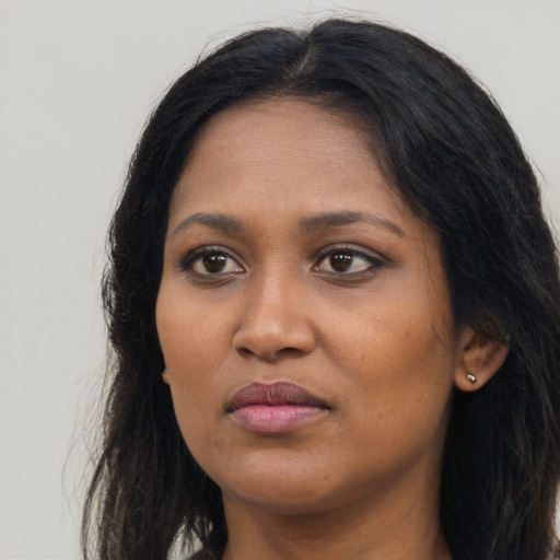 Joyful black young-adult female with long  brown hair and brown eyes