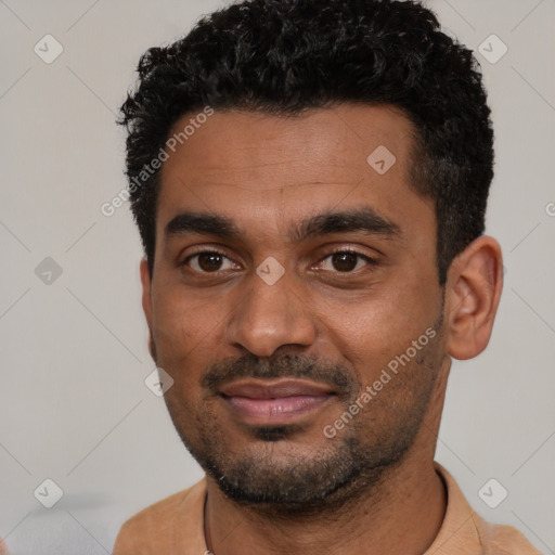 Joyful black young-adult male with short  black hair and brown eyes