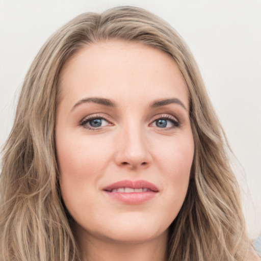 Joyful white young-adult female with long  brown hair and blue eyes