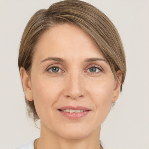 Joyful white adult female with medium  brown hair and grey eyes