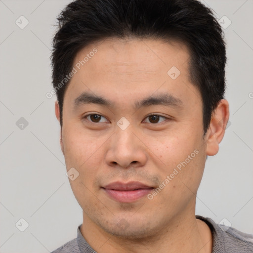 Joyful asian young-adult male with short  brown hair and brown eyes