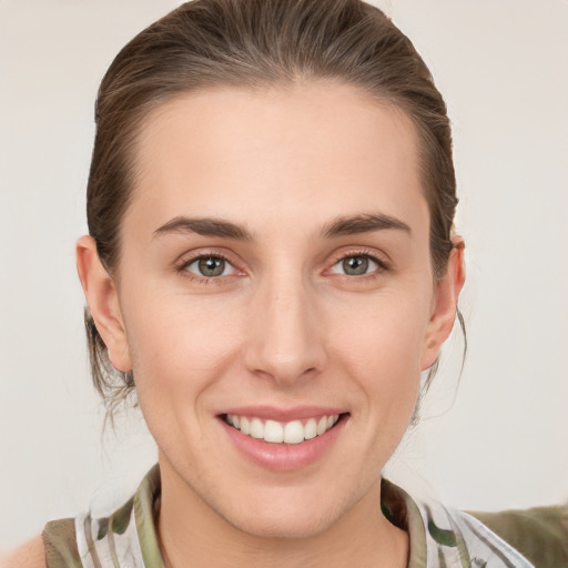 Joyful white young-adult female with medium  brown hair and grey eyes