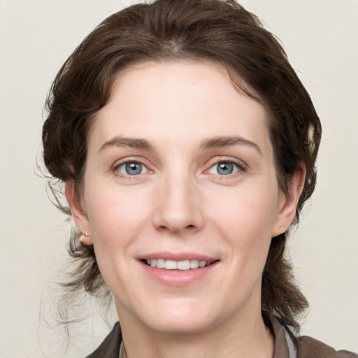 Joyful white young-adult female with medium  brown hair and grey eyes