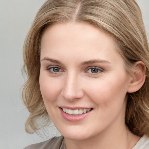 Joyful white young-adult female with medium  brown hair and blue eyes