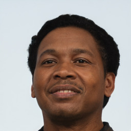 Joyful black adult male with short  black hair and brown eyes