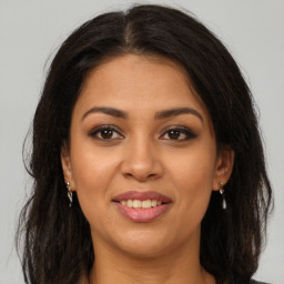 Joyful latino young-adult female with long  brown hair and brown eyes