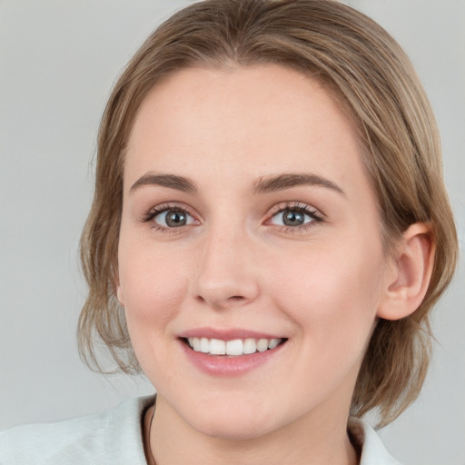 Joyful white young-adult female with medium  brown hair and blue eyes