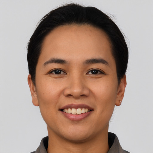 Joyful latino young-adult female with short  black hair and brown eyes