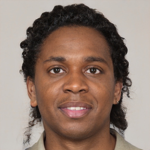 Joyful black young-adult male with medium  black hair and brown eyes