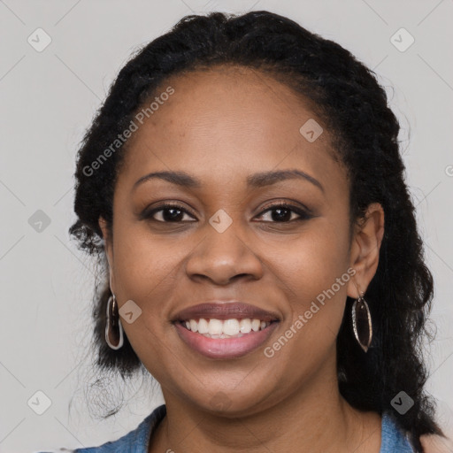 Joyful black young-adult female with long  black hair and brown eyes