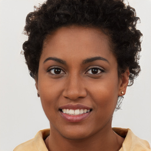 Joyful black young-adult female with short  brown hair and brown eyes