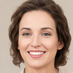 Joyful white young-adult female with medium  brown hair and green eyes