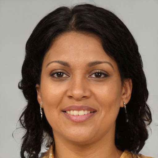Joyful latino adult female with long  brown hair and brown eyes