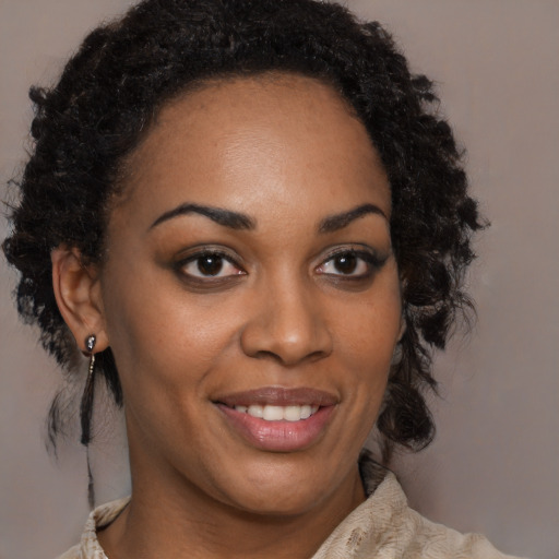 Joyful black young-adult female with long  brown hair and brown eyes