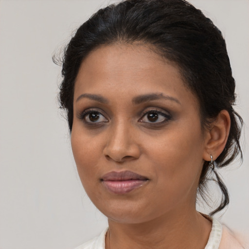Joyful black young-adult female with medium  brown hair and brown eyes