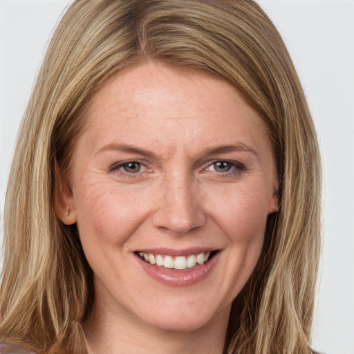 Joyful white adult female with long  brown hair and grey eyes