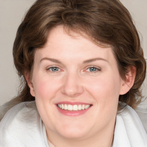 Joyful white young-adult female with medium  brown hair and blue eyes