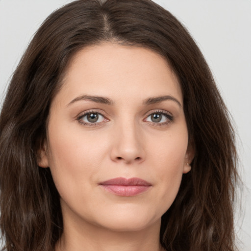 Joyful white young-adult female with long  brown hair and brown eyes