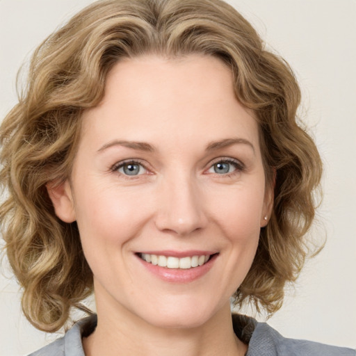 Joyful white young-adult female with medium  brown hair and blue eyes