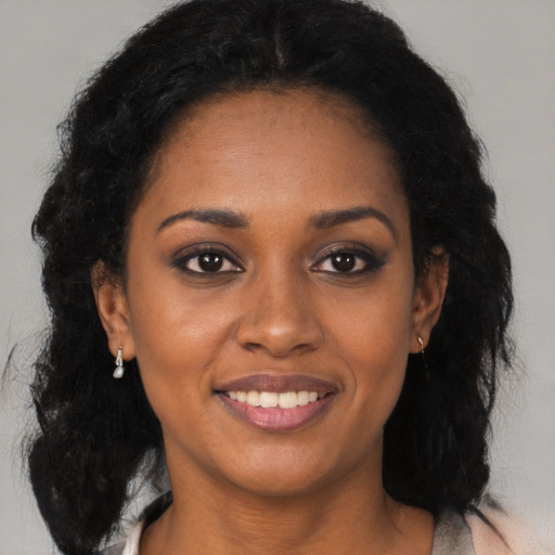 Joyful black young-adult female with long  black hair and brown eyes