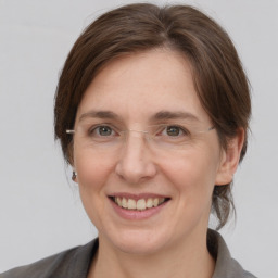 Joyful white adult female with medium  brown hair and grey eyes