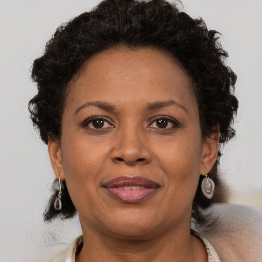 Joyful black adult female with short  brown hair and brown eyes