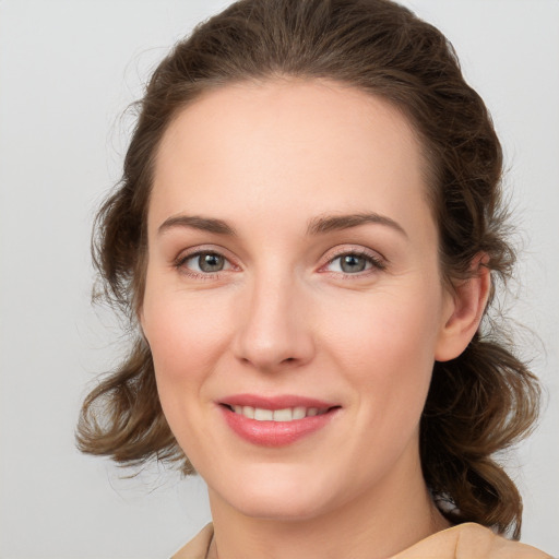 Joyful white young-adult female with medium  brown hair and green eyes