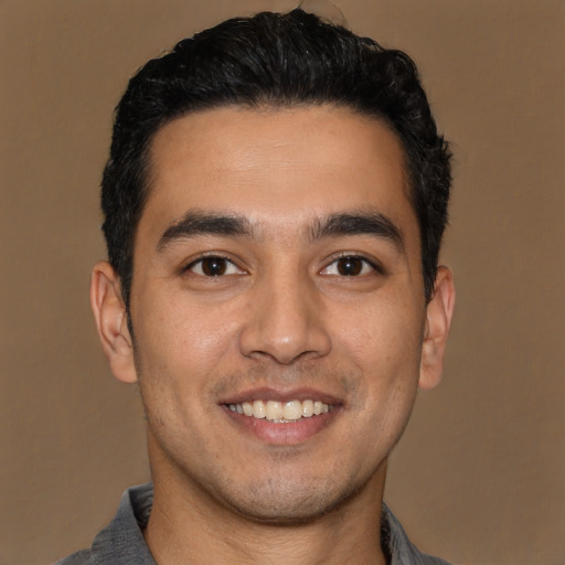 Joyful latino young-adult male with short  black hair and brown eyes