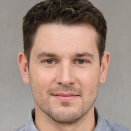 Joyful white young-adult male with short  brown hair and grey eyes