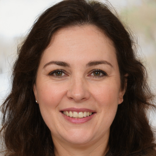 Joyful white adult female with long  brown hair and brown eyes