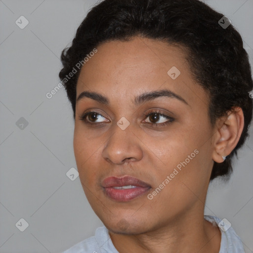 Joyful black young-adult female with short  black hair and brown eyes