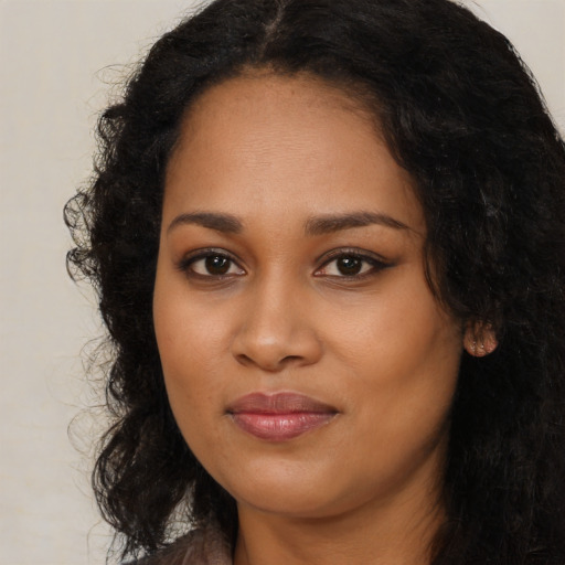 Joyful black young-adult female with long  black hair and brown eyes
