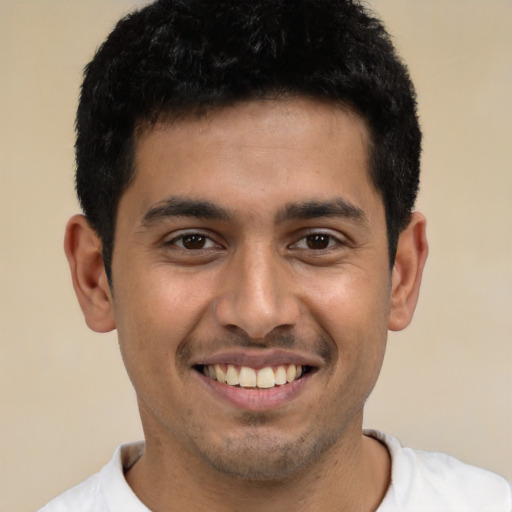Joyful latino young-adult male with short  black hair and brown eyes