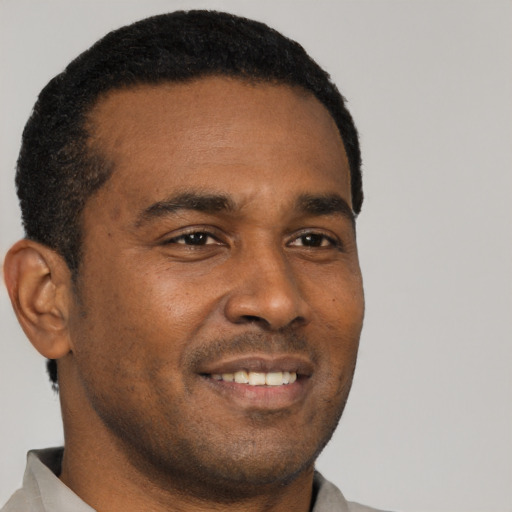 Joyful black young-adult male with short  black hair and brown eyes