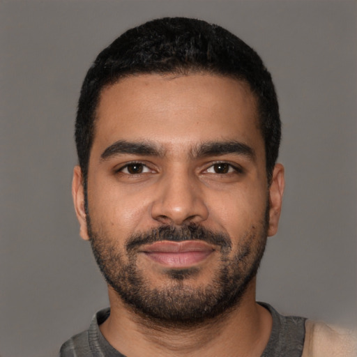 Joyful latino young-adult male with short  brown hair and brown eyes