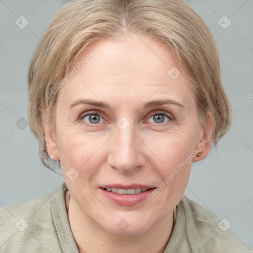 Joyful white adult female with medium  brown hair and blue eyes