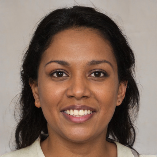 Joyful black young-adult female with medium  brown hair and brown eyes