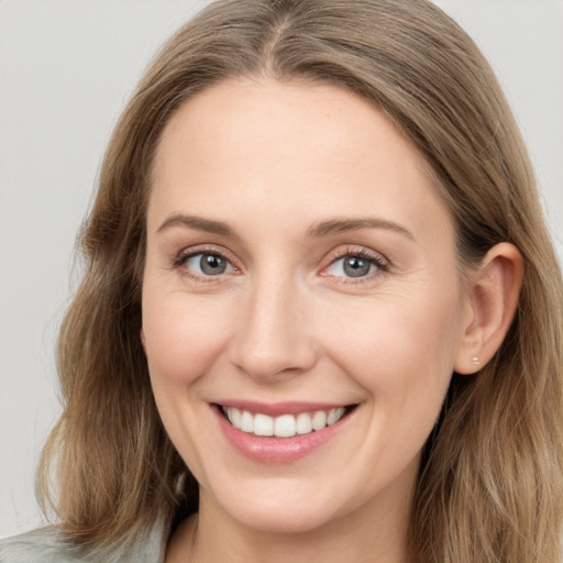 Joyful white young-adult female with long  brown hair and blue eyes