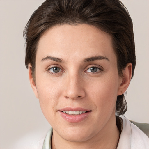 Joyful white young-adult female with short  brown hair and grey eyes