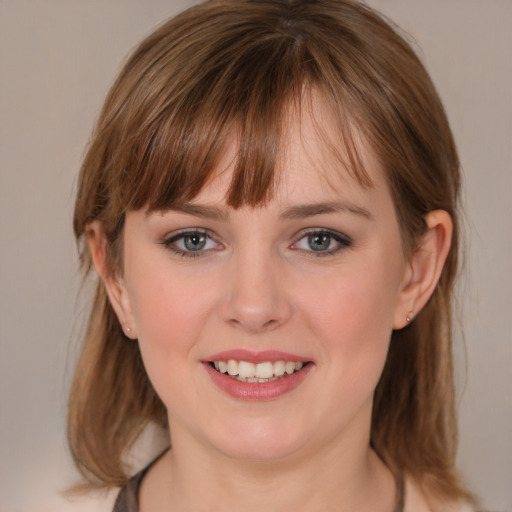 Joyful white young-adult female with medium  brown hair and grey eyes