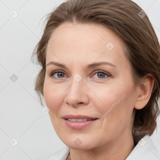 Joyful white adult female with medium  brown hair and grey eyes