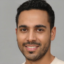 Joyful latino young-adult male with short  black hair and brown eyes