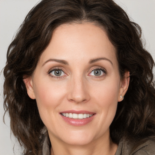 Joyful white young-adult female with medium  brown hair and green eyes